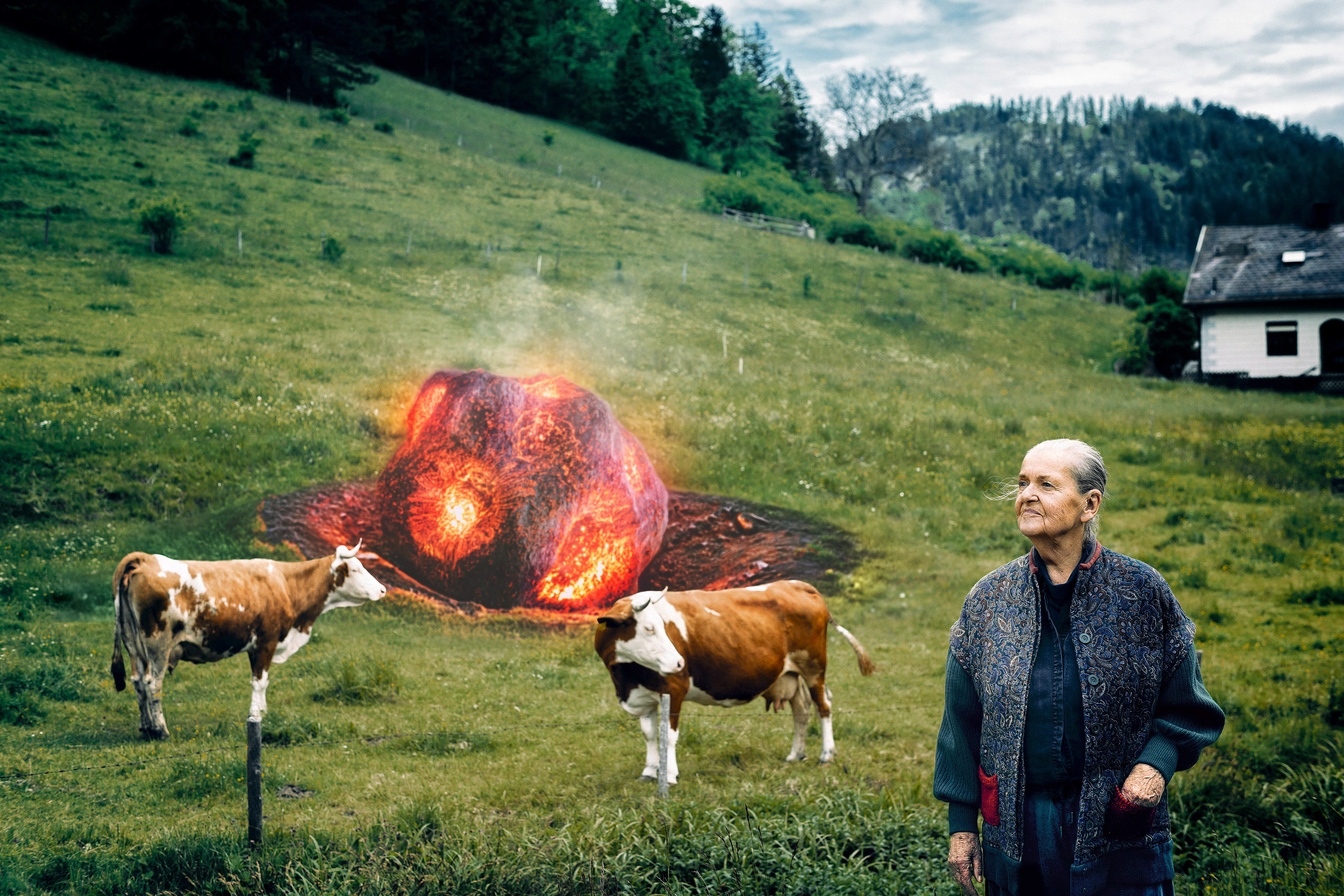 Zwei Kühe und eine ältere Frau auf einer grünen Wiese betrachten einen großen, leuchtenden Meteoriten im Boden.